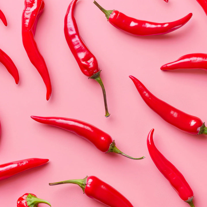 Red chili peppers on a pink background